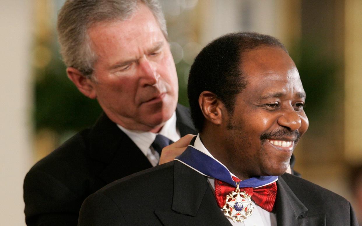 Paul Rusesabagina receives the Presidential Medal of Freedom from George W Bush in 2005, the year after Hotel Rwanda was released - AP