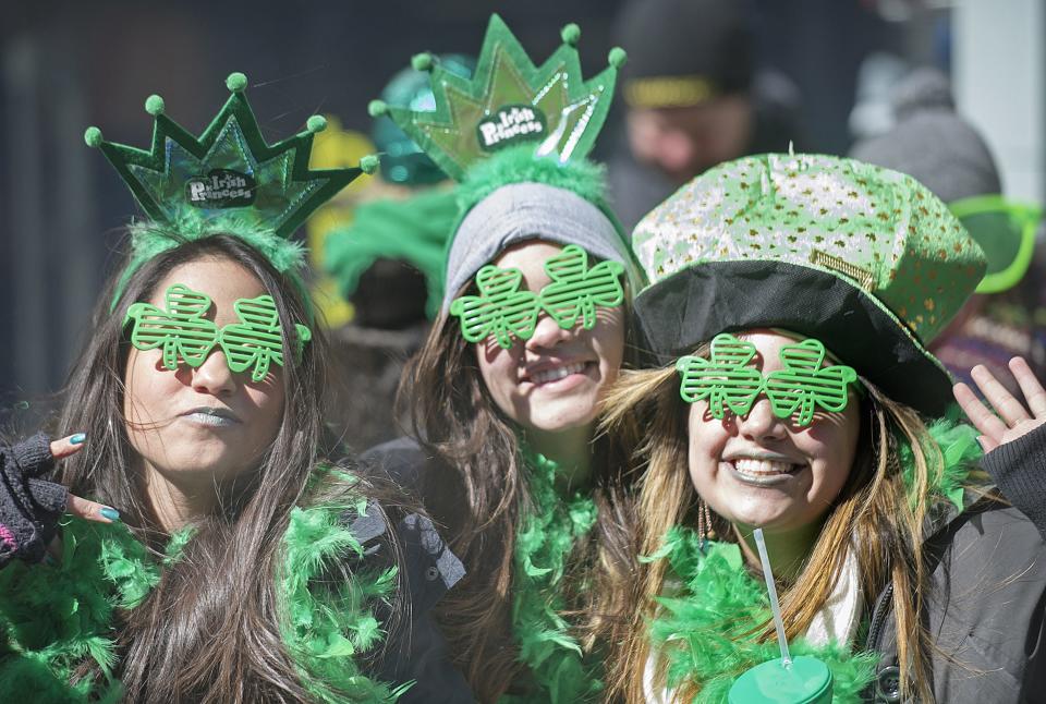 Spectators smile as the watch the annual St. Patrick's Day parade in Montreal, Sunday, March 16, 2014. (AP Photo/The Canadian Press, Graham Hughes)