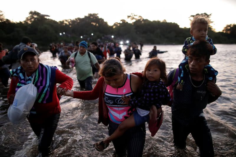 Migrants, mainly from Central America, marching in a caravan cross the Suchiate river on the outskirts of Ciudad Hidalgo