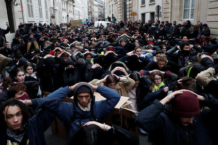 Students and high school students kneel in a street during a demonstration to protest against the French government's reform plan, in Paris, December 11, 2018. REUTERS/Benoit Tessier