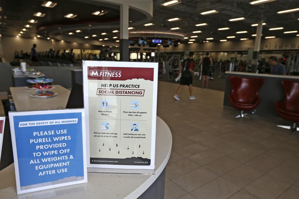 Mountainside Fitness posts their safety guidelines as the facility remains open even as Arizona Gov. Doug Ducey has issued an executive order for all gyms to close due to the surge in coronavirus cases in Arizona Thursday, July 2, 2020, in Phoenix. For the third straight day, several health clubs in metro Phoenix were defying Ducey's 30-day shutdown order to close gyms, bars, water park and tubing businesses, raising questions about whether officials who have been criticized for responding indecisively to the pandemic will be effective in shutting down the clubs. (AP Photo/Ross D. Franklin)