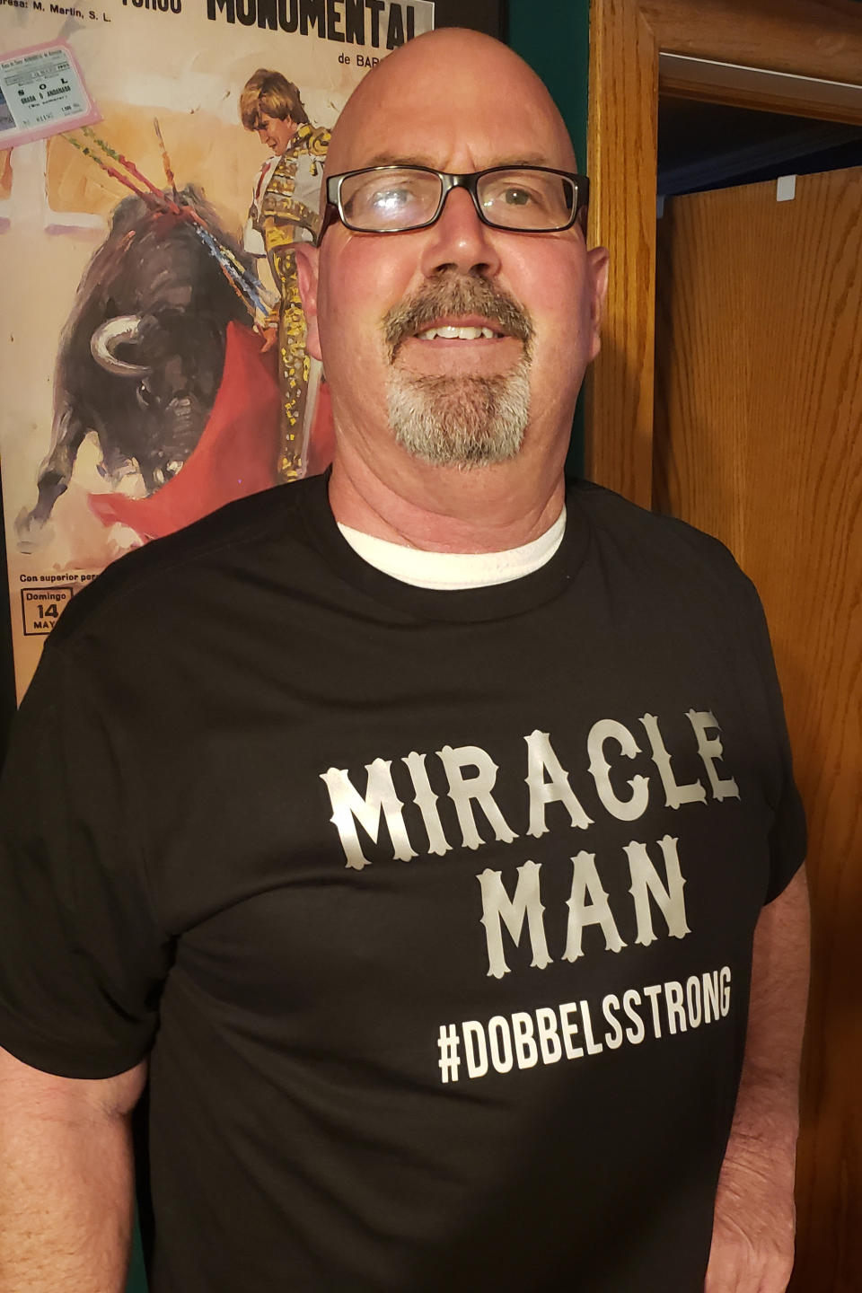 This May 4, 2020 photo provided by Elizabeth Dobbels shows her husband, Scott. Struck by COVID-19, he spent 17 days in the hospital, eight of them on a ventilator. He returned to his home in Silvis, Ill. on April 20 weighing 20 pounds less and pushing a metal walker. At first, just brushing his teeth was an effort. After several sessions with a physical therapist, he’s regaining muscle and strength. And to exercise his damaged lungs, he blows into a special inhaler several times a day. Dobbels says he feels great, despite lingering muscle pain and some weakness, and plans to return to work May 13. (Elizabeth Dobbels via AP)