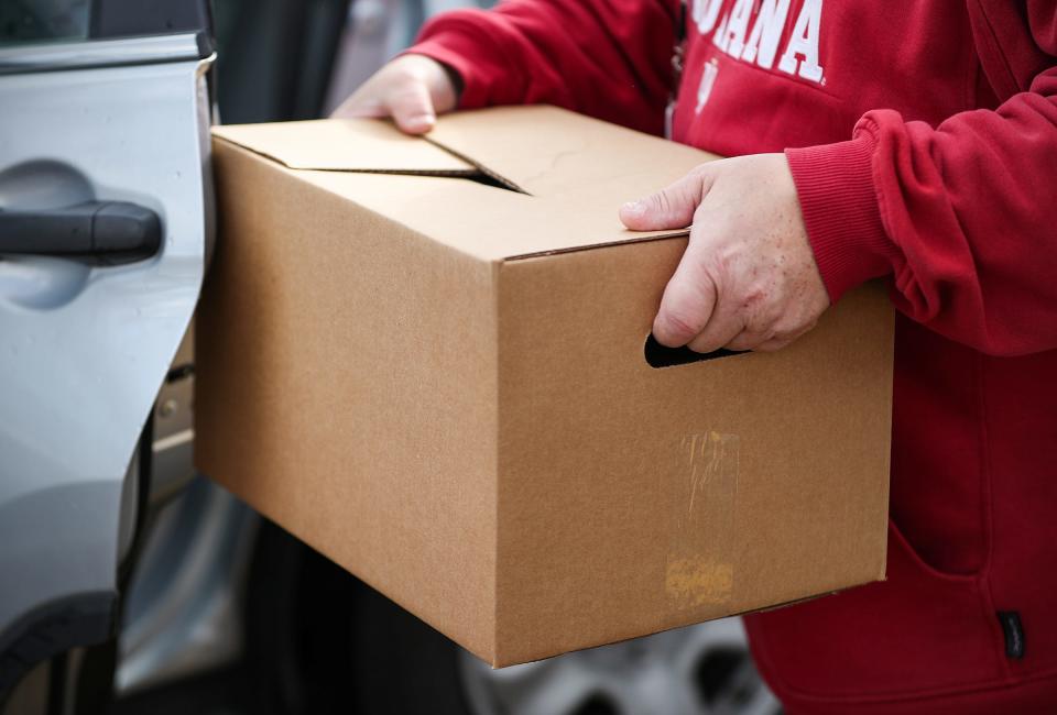 Indy residents partake in a drive-thru food and gift giveaway at Flanner House in Indianapolis, a socially distant version of its annual holiday program, on Saturday, Dec. 12, 2020. Flanner House is a northwest-side social services agency that has been helping Indianapolis residents for more than a century.