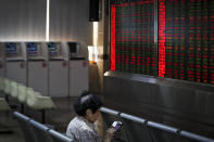 A woman checks stock prices through her smartphone at a brokerage house in Beijing, Wednesday, May 22, 2019. Shares edged in Asia on Wednesday after a rebound in technology stocks helped power an overnight rally on Wall Street. (AP Photo/Andy Wong)