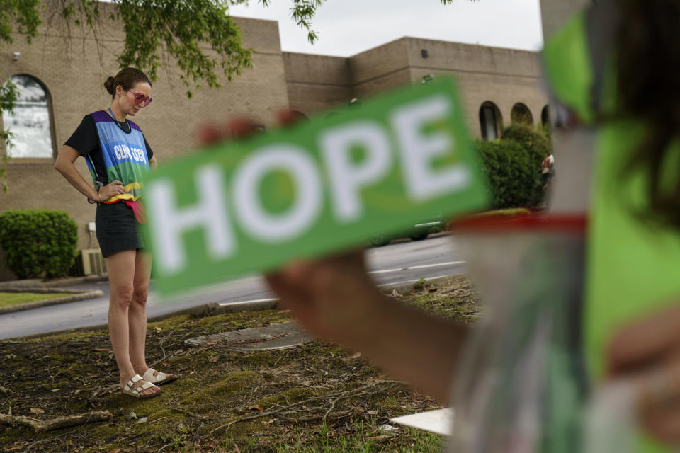 Planned Parenthood advocacy programs manager, Allison Terracio, left, stands outside the clinic to escort patients showing up for abortion appointments as Valerie Berry, program manager for the anti-abortion group, A Moment of Hope, holds up a sign at the entrance in Columbia, S.C., Friday, May 27, 2022. After decades of tiny steps and endless setbacks, America's anti-abortion movement is poised for the possibility of a massive leap. With the Supreme Court due to deliver a landmark ruling expected to seriously curtail or completely overturn the constitutional right to abortion found in the 49-year-old Roe v. Wade decision, anti-abortion advocates across the U.S. are hopeful they'll be recording a win. (AP Photo/David Goldman)