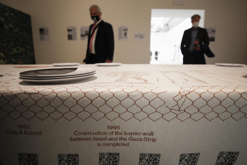 Visitors look at the installation "Border Ecologies And The Gaza Strip" during the exhibition "How will we live together?", at the Biennale International Architecture, in Venice, Italy, Wednesday, May 19, 2021. The 17th International Architecture Exhibition opens Saturday after a one-year pandemic delay, during which time architecture has emerged as one of the key disciplines in the global coronavirus response. (AP Photo/Alessandra Tarantino)