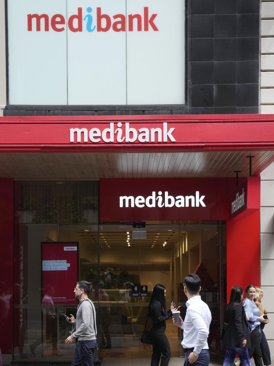 People walk past a Medibank branch in Sydney, Thursday, Oct. 20, 2022. Medibank health insurer is being extorted for customers' data in the nation's second major cybersecurity breach in a month, an official says. (AP Photo/Rick Rycroft)