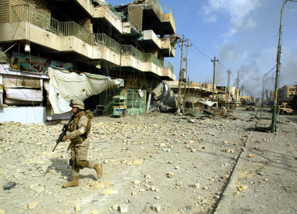 A US marine from the 3/5 Lima company walks towards a destroyed building along the main street in the restive city of Fallujah in 2004 (AFP/Getty)