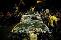 Protesters shout slogans next to a damaged Spanish Civil Guard patrol car outside the Catalan region's economy ministry building during a raid by Spanish police on government offices, in Barcelona, Spain, early September 21, 2017. REUTERS/Jon Nazca