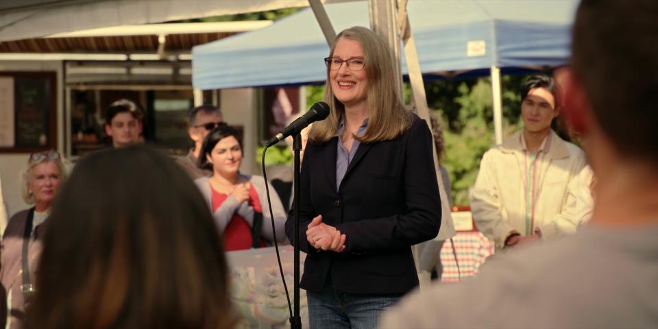 Hope talking in a microphone surrounded by the residents.