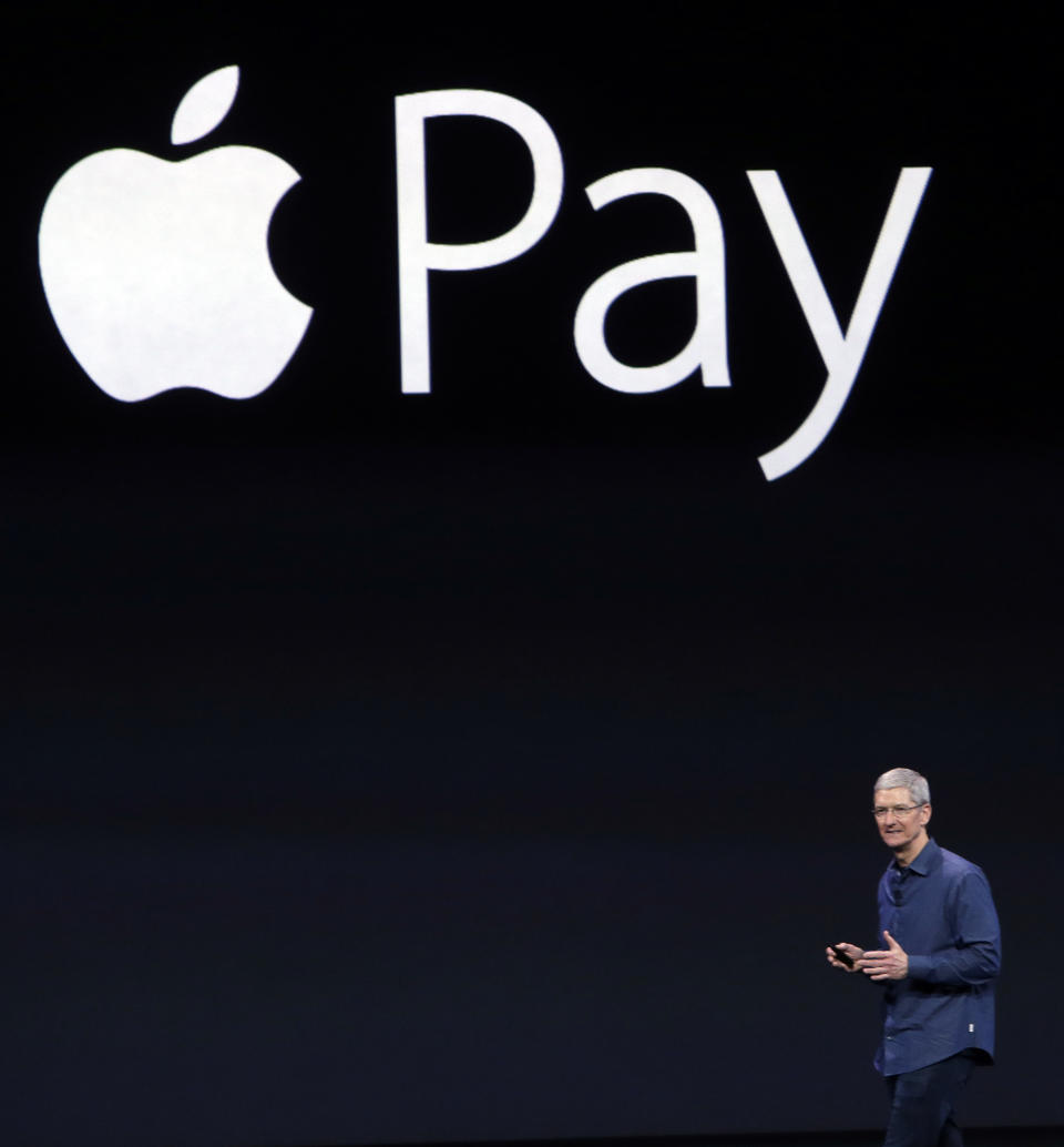 FILE - In this Sept. 9, 2014, file photo, Apple CEO Tim Cook introduces the new Apple Pay product in Cupertino, Calif. In its first move since getting a new director, the Consumer Financial Protection Bureau is ordering Apple, Amazon, PayPal and other tech giants to disclose how they operate their proprietary payment networks, which have to come to dominate large portions of e-commerce and person-to-person payments. (AP Photo/Marcio Jose Sanchez, File)