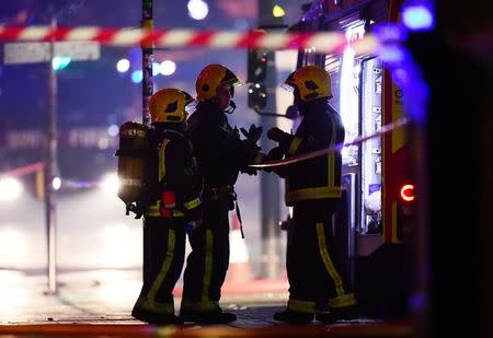 Firefighters stand near a fire at Camden Market in north London, Britain, July 10, 2017. REUTERS/Hannah McKay