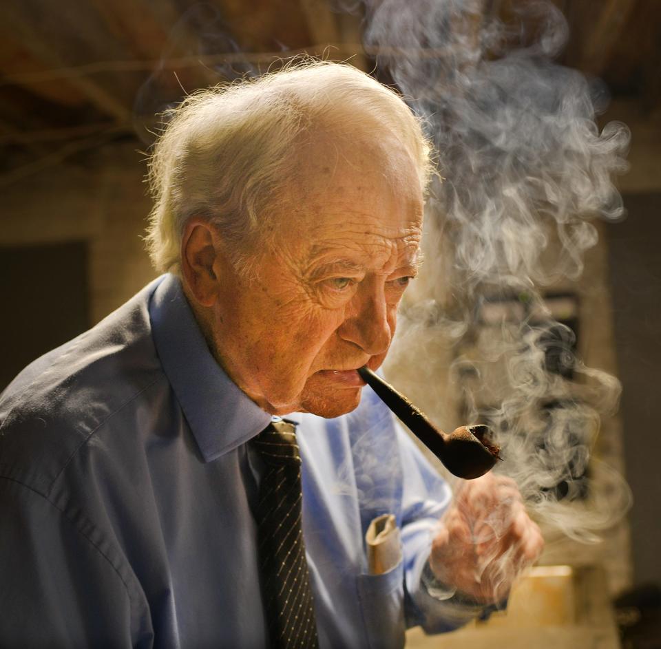 Peter A. Stefan lights his pipe in the basement of Graham Putnam & Mahoney Funeral Parlors June 1, 2021. Stefan, who died March 21, recounted some memorable moments from his career in a book titled "Mumblings of a Mortician," written by Frank Quaglia and Art Sesnovich.
