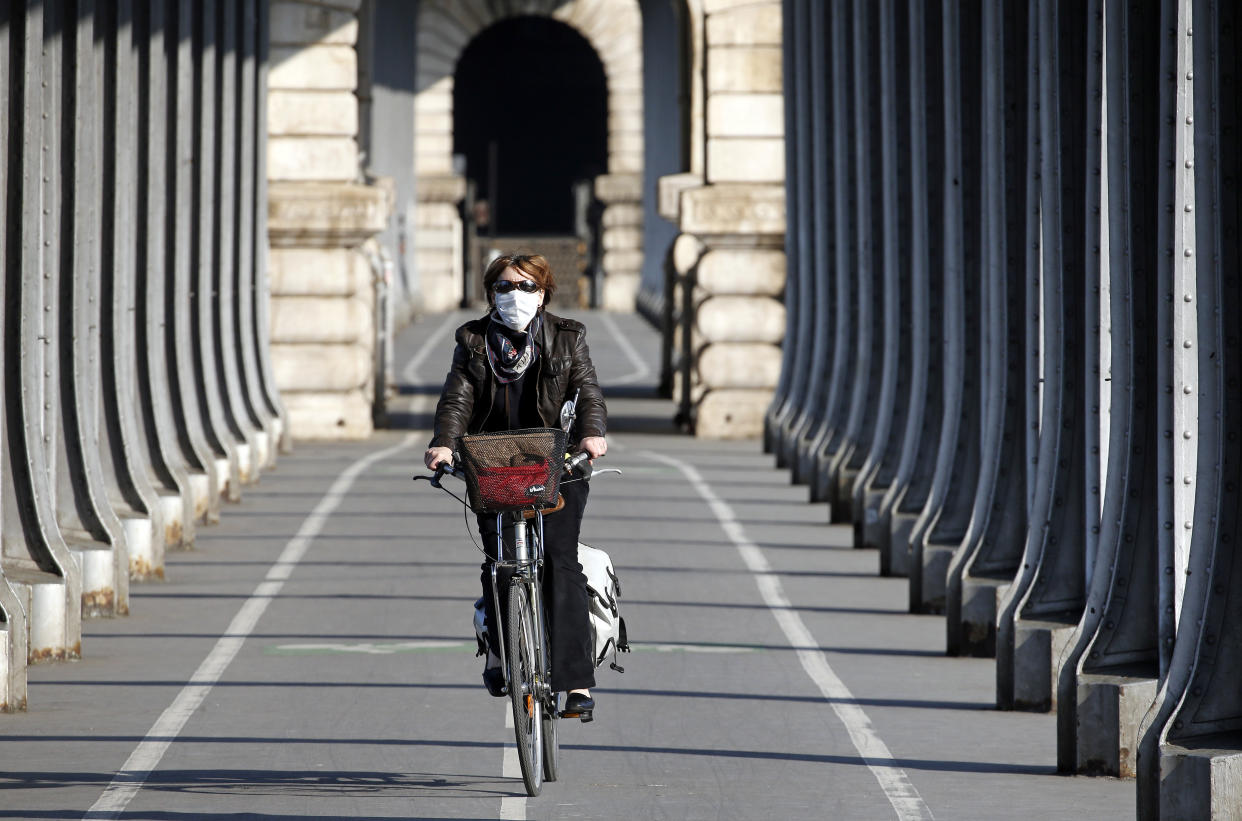 PARIS, FRANCE - APRIL 24: A woman wearing a protective face mask rides her bicycle under the Bir Hakeim bridge as the lockdown continues due to the coronavirus outbreak (COVID 19) on April 24, 2020 in Paris, France. The Coronavirus (COVID-19) pandemic has spread to many countries across the world, claiming over 191,000 lives and infecting over 2.7 million people. (Photo by Chesnot/Getty Images)
