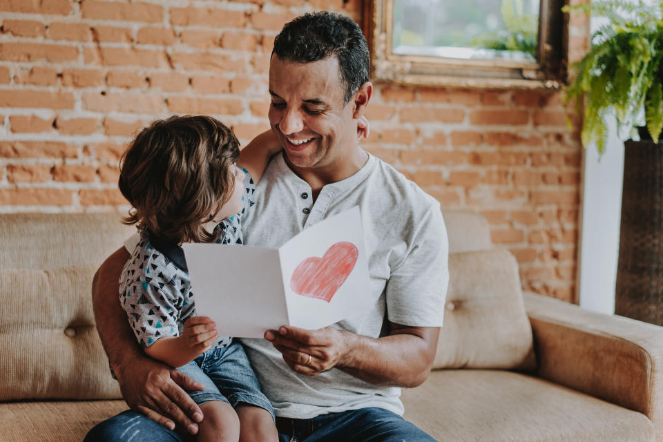 Son handing postcard to father on father's day