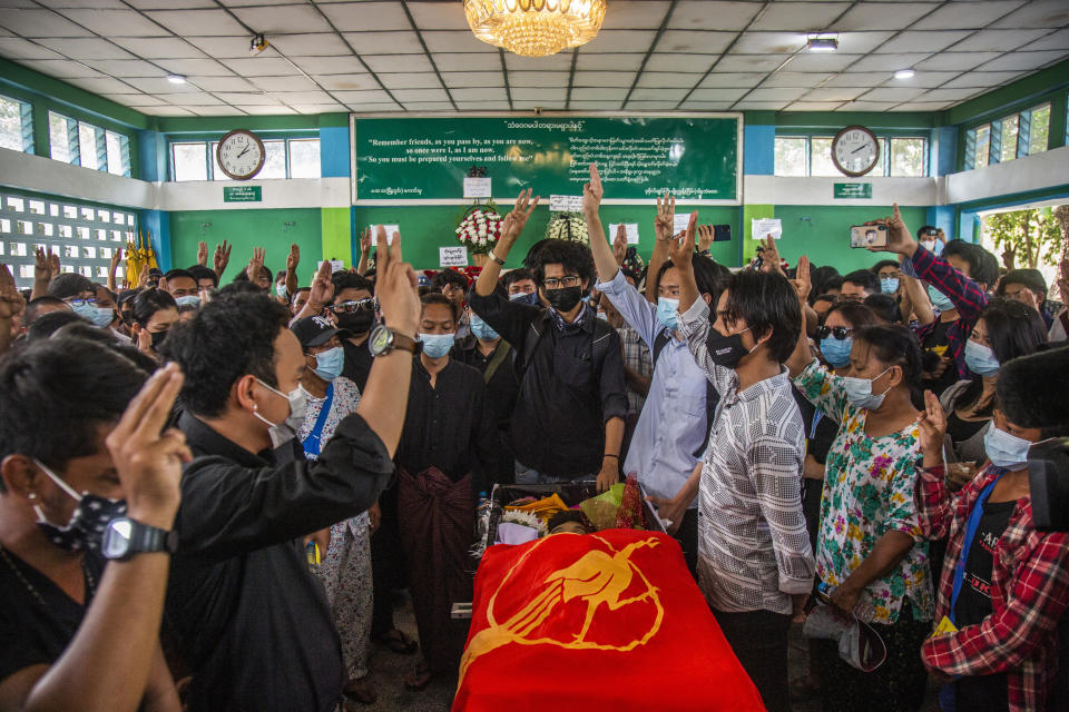 People flash three-fingered salute during the funeral of Khant Ngar Hein in Yangon, Myanmar Tuesday, March 16, 2021. Khant Ngar Hein, a 18-year old student of medicine was shot on his chest on Sunday, March 14 in Tamwe, Yangon by security forces during an anti-crop protest. (AP Photo)
