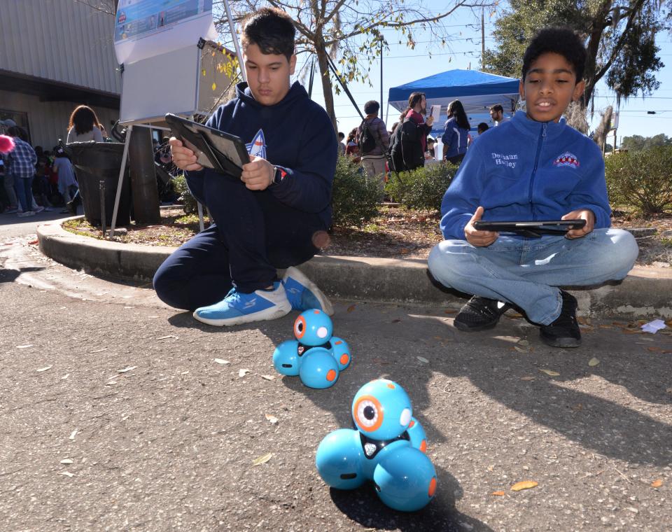 River City Science Academy students Joshua Negron and Deshaun Hadley manuever DASH the robot by using a computer tablet in this 2020 photo of a STEM and halth expo at the main Jacksonville campus of River City Science, which had three facilities in Duval County the state labeled as "schools of excellence."