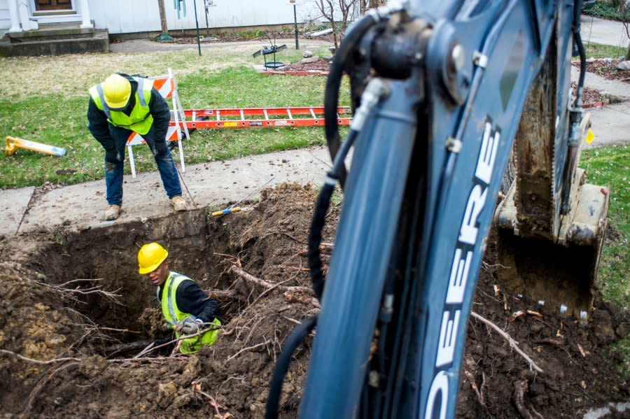 FILE – In this Wednesday, April 18, 2018 file photo, Flint resident Jabaree Broach, 24, works as part of a crew digging out and replacing lead service lines on Flint, Mich.’s east side. Tens of billions of dollars for U.S. environmental justice initiatives originally proposed in a $3.5 trillion domestic spending package now hang in the balance as Democrats decide how to trim the bill down to $2 trillion in October 2021. (Jake May/The Flint Journal-MLive.com via AP, File)