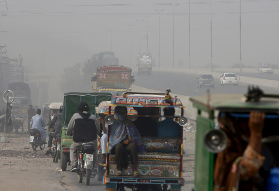 People travel on a road as smog envelops the area of Lahore, Pakistan, Wednesday, Nov. 11, 2020. People in Pakistan’s cultural capital of Lahore were at risk of respiratory diseases and eye-related problems Wednesday after the air quality deteriorated to hazardous levels due to a quilt of smog over the city, prompting doctors to urge people to stay at home. (AP Photo/K.M. Chaudary)