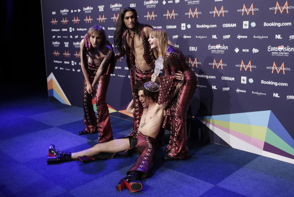 Members of the band Maneskin from Italy Thomas Raggi, from left, Ethan Torchio, Victoria De Angelis and Damiano David, on floor, pose for photographers with the trophy after winning the Grand Final of the Eurovision Song Contest at Ahoy arena in Rotterdam, Netherlands, Saturday, May 22, 2021. (AP Photo/Peter Dejong)