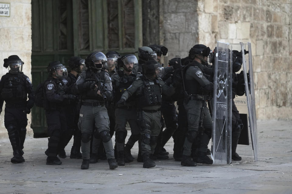 Israeli police move behind riot shields during clashes with Palestinian protesters at the Al Aqsa Mosque compound in Jerusalem's Old City, Friday, April 22, 2022. (AP Photo/Mahmoud Illean)