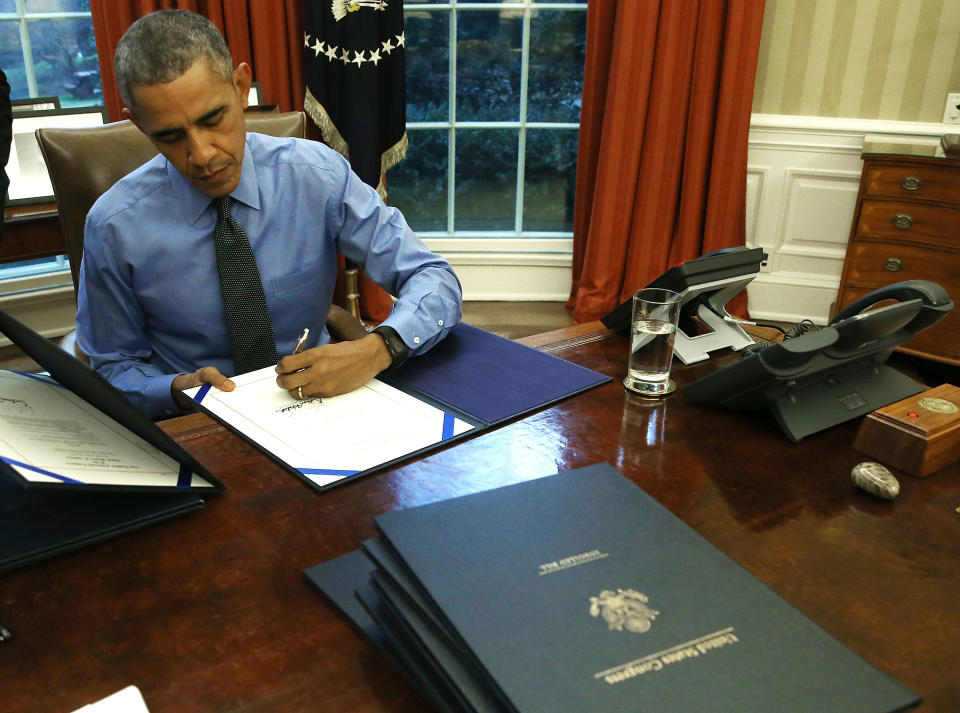 El presidente Barack Obama firma documentos en su escritorio de la Oficina Oval. Junto al teléfono, el botón especial en su caja de madera. (Photo by Mark Wilson/Getty Images)