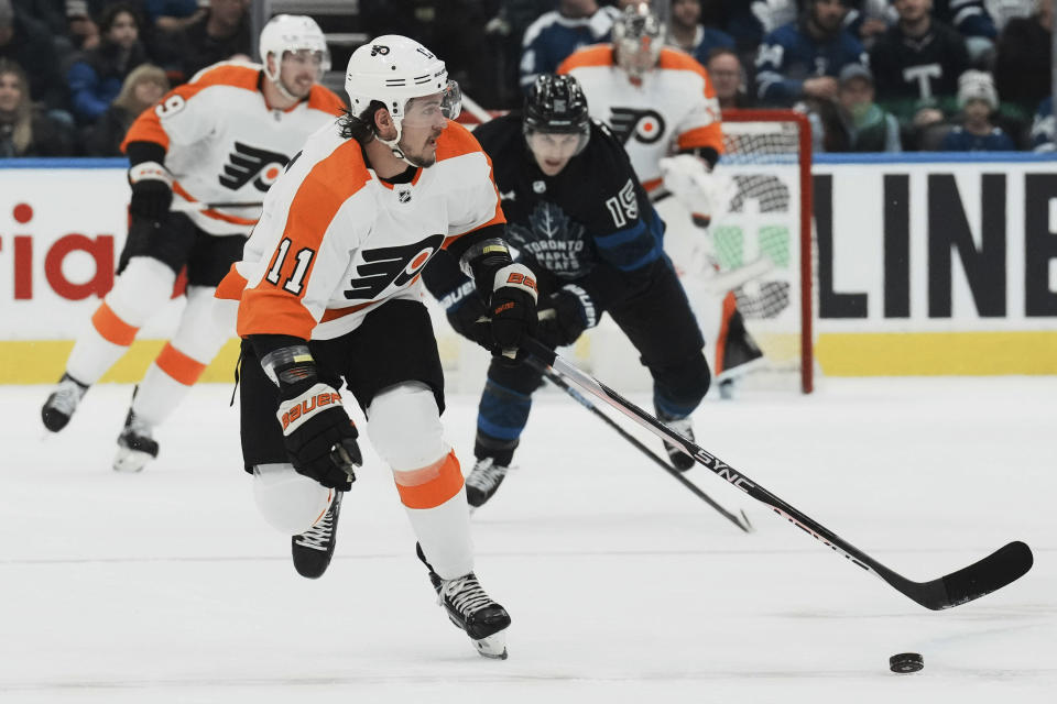 Philadelphia Flyers right wing Travis Konecny (11) looks up ice as Toronto Maple Leafs center Alexander Kerfoot (15) gives chase during the first period of an NHL hockey game in Toronto, Thursday, Dec. 22, 2022. (Chris Young/The Canadian Press via AP)