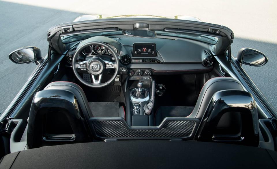 <p>The Miata cabin is snug-no surprise there-but, although Mazda offers classy touches such as body-color upper door panels and cut-and-sewn dash trim with contrast stitching, luxury really isn't the point. What matters in the Miata is its large, front-and-center tachometer; its snug sport seats; and its new tilting and telescoping steering column, which makes it much easier for longer-legged drivers to find a comfortable seating position. </p><p>With so little real estate to work with in the tight cabin, the cupholders are cast off to an inconvenient spot between the passengers' shoulders. Access is best accomplished by reaching across one's body with the opposite hand.<br></p>