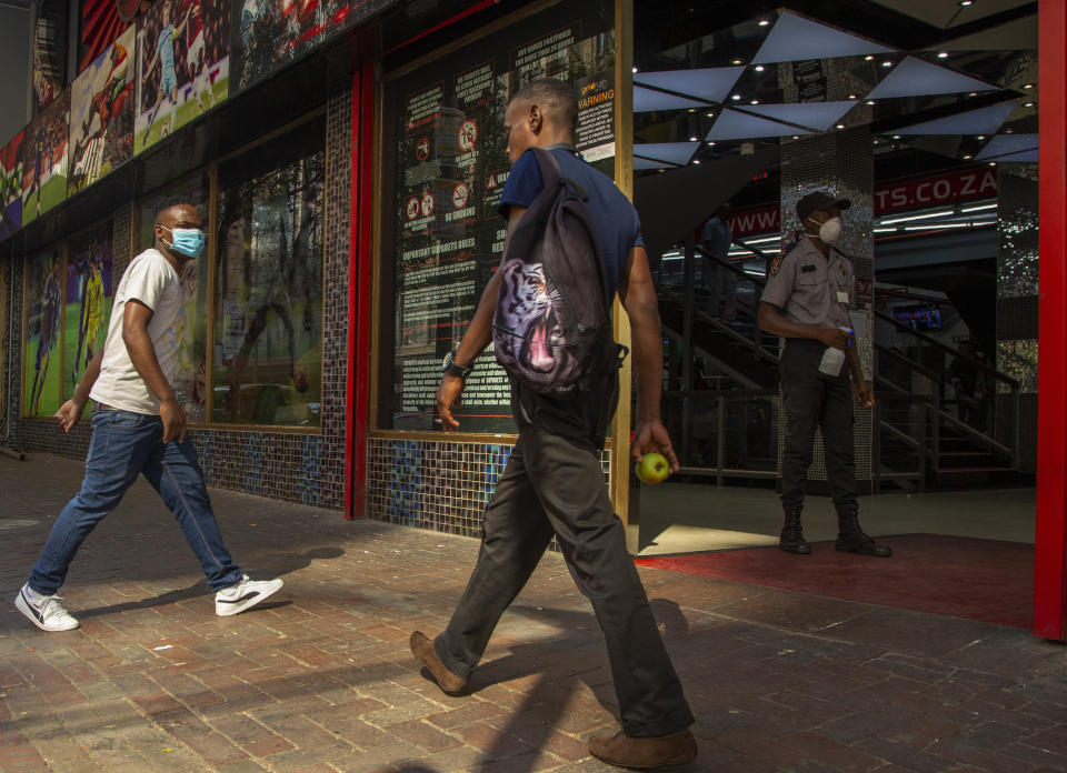 A man wearing a surgical mask walks to a shop in downtown Johannesburg, South Africa, Friday, March 20, 2020. Anxiety rose in Africa’s richest nation Friday as South Africa as coronavirus cases jumped to 202, the most in the sub-Saharan region, while the continent's busiest airport said foreigners cannot disembark. State-owned South African Airways suspended all international flights until June. For most people, the new coronavirus causes only mild or moderate symptoms, such as fever and cough. For some, especially older adults and people with existing health problems, it can cause more severe illness, including pneumonia. (AP Photo/Themba Hadebe)
