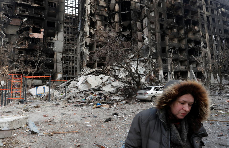 Nurse Svetlana Savchenko stands next to a destroyed building in the besieged city of Mariupol, Ukraine.