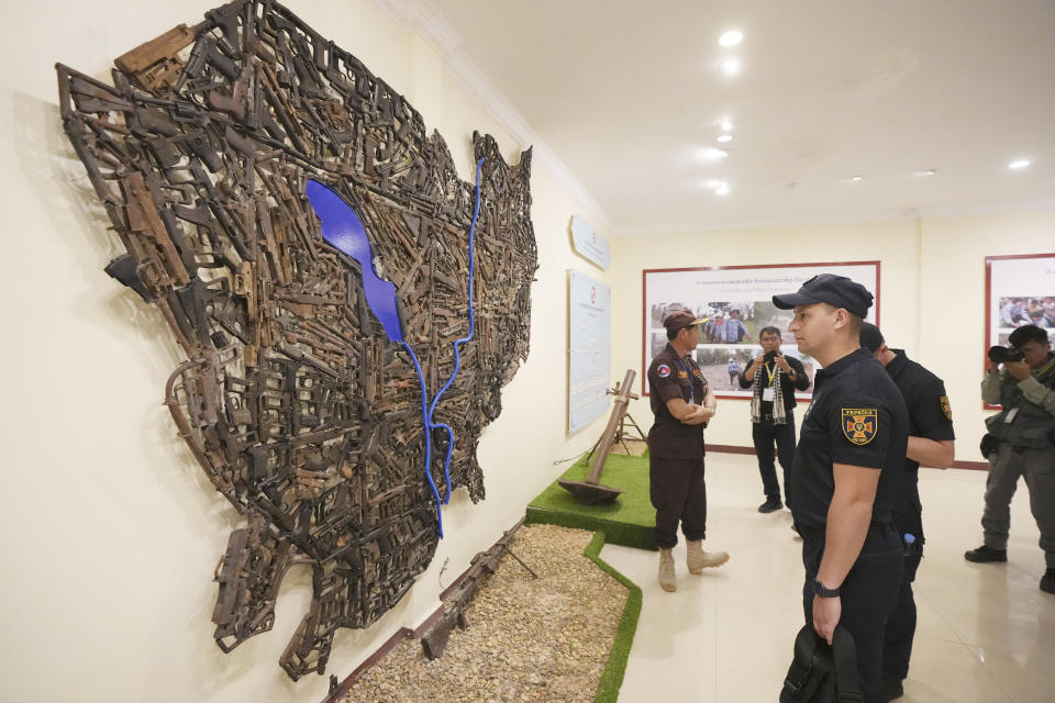 A Ukrainian deminer views a Cambodia's country map made with old war weapons during a tour to Peace Museum Mine Action in Siem Reap province of northwestern Cambodia, Friday, Jan. 20, 2023. Cambodian experts, whose country has the dubious distinction of being one of the world's most contaminated by landmines, walked a group of Ukrainian soldiers through a minefield being actively cleared hoping their decades of experience will help the Europeans in their own efforts to remove Russian mines at home. (AP Photo/Heng Sinith)