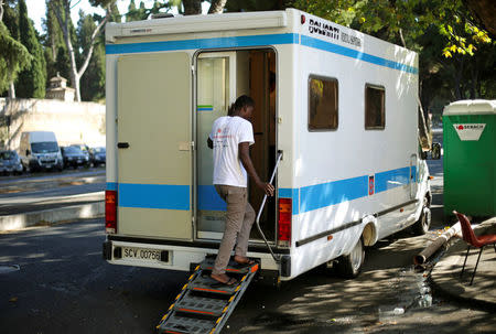 A migrant enters a Vatican sanitary vehicle, run by volunteers, at a makeshift camp in Via Cupa (Gloomy Street) in downtown Rome, Italy, August 1, 2016. REUTERS/Max Rossi