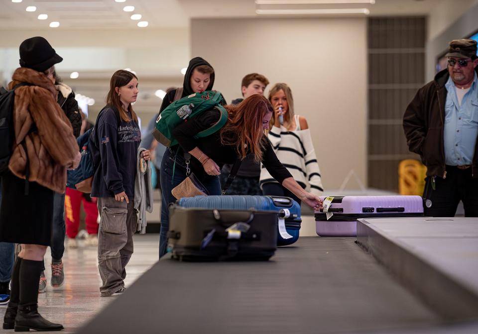 Holiday travelers wait for their bags after arriving at Muhammad Ali International Airport. Four new modern bag belts were recently installed and are now up and running as part of a $10 million dollar SDF Next program. Nov. 21, 2023.