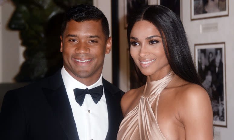 Russell Wilson posing for a photo with Ciara.