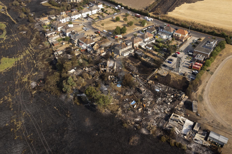 The scene after a blaze in the village of Wennington, east London, Wednesday July 20, 2022. Britain shattered its record for highest temperature ever registered Tuesday amid a heat wave that has seared swaths of Europe, as the U.K.'s national weather forecaster said such highs are now a fact of life in a country ill-prepared for such extremes. (Aaron Chown/PA via AP)