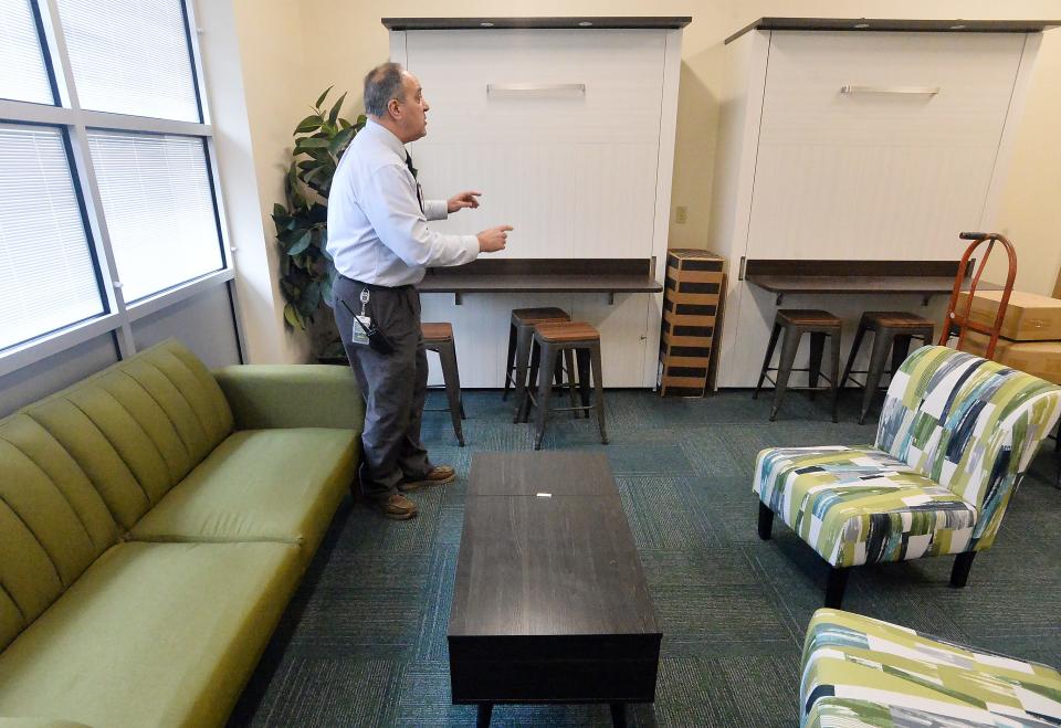 Erie County Technical School Director Joe Tarasovitch describes features of a new hospitality lab, made to mimic a hotel room and front-desk area.