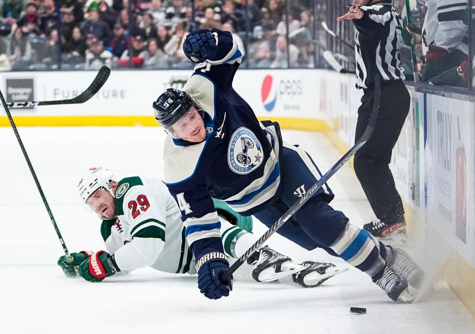 Minnesota Wild defenseman Dmitry Kulikov (29) trips Columbus Blue Jackets center Gustav Nyquist (14) during the first period of the NHL hockey game at Nationwide Arena in Columbus on March 11, 2022.