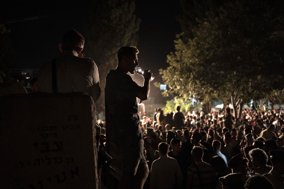 A mourner slips water at the funeral for Maj. Bar Falah, killed during a West Bank operation, in Netanya, Israel, Wednesday, Sept. 14, 2022. Palestinian gunmen opened fire on Israeli troops near a military checkpoint in the occupied West Bank Wednesday, killing Maj. Falah, Israel's military said. Palestinian officials said that troops killed the two gunmen.(AP Photo/ Maya Alleruzzo)