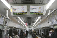 Electric screens about precautions against the COVID-19 illness are seen in a subway train in Seoul, South Korea, Monday, April 6, 2020. The new coronavirus causes mild or moderate symptoms for most people, but for some, especially older adults and people with existing health problems, it can cause more severe illness or death. (AP Photo/Ahn Young-joon)