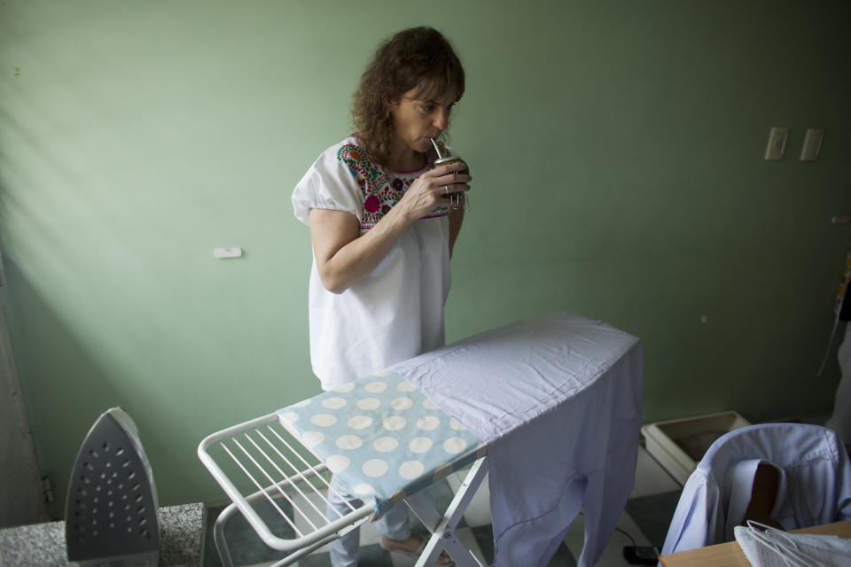 In this April 8, 2014 photo, Maria Eugenia Diez drinks a "mate," a traditional drink as she pauses from ironing, in her home in Buenos Aires, Argentina. On Thursday, April 10, 2014, a nationwide strike paralyzed Argentina’s public transportation, all non-emergency hospital attention and other sections of public life. Diez, a middle-class housewife, says she's sympathetic to the union workers' salary woes and supports many of the government's efforts to direct resources to the poor, but thinks the strike just takes more money from everyone's pockets. (AP Photo/Victor R. Caivano)