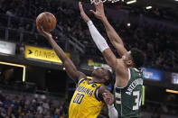 Indiana Pacers' Bennedict Mathurin (00) puts up a shot against Milwaukee Bucks' Giannis Antetokounmpo (34) during the first half of an NBA basketball game, Friday, Jan. 27, 2023, in Indianapolis. (AP Photo/Darron Cummings)