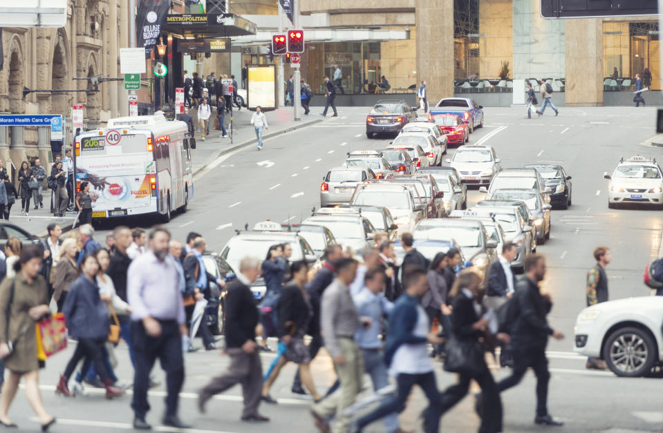 Pedestrians walk across a busy Bridge Street near Circular Quay intersection in Sydney.