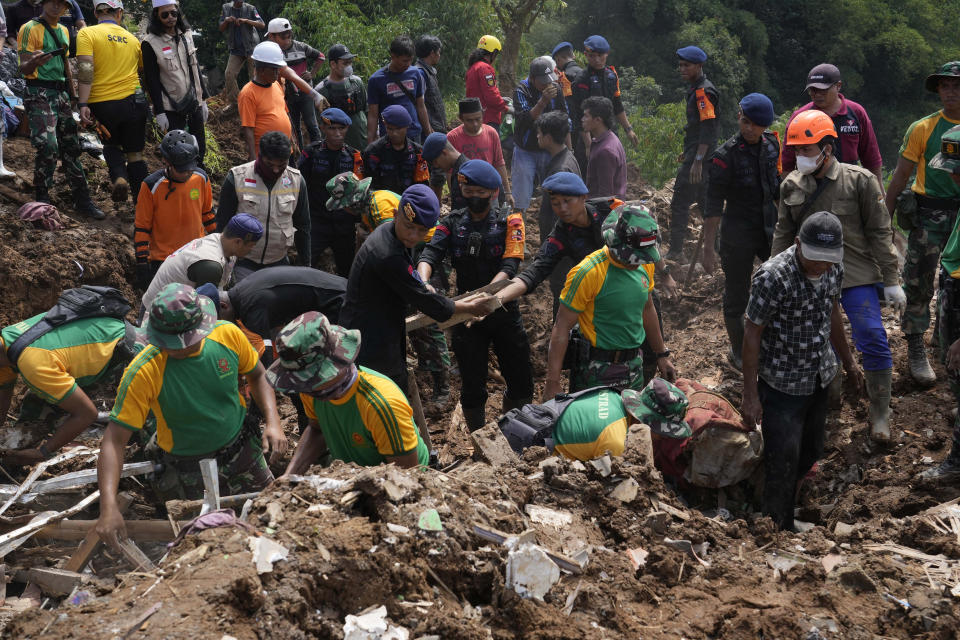 Rescuers search for victims of an earthquake-triggered landslide in Cianjur, West Java, Indonesia, Wednesday, Nov. 23, 2022. More rescuers and volunteers were deployed Wednesday in devastated areas on Indonesia's main island of Java to search for the dead and missing from an earthquake that killed hundreds of people. (AP Photo/Tatan Syuflana)