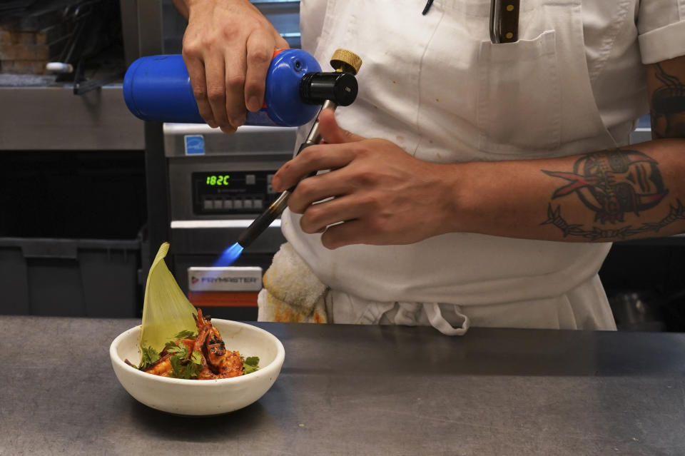 Un chef prepara un platillo de camarones en el restaurante Caracol de Mar de la renombrada chef y empresaria mexicana Gabriela Cámara, el miércoles 27 de julio de 2022 en la Ciudad de México. Cámara aparece en el popular programa de TV estadounidense "Iron Chef", que exalta la cocina mexicana. También ha abierto varios restaurantes y es autora del libro de recetas "Mi cocina de Ciudad de México". (Foto AP/Marco Ugarte)