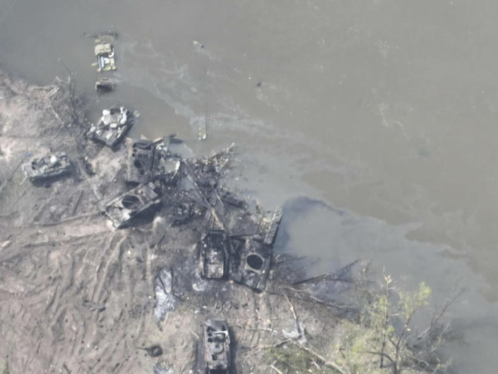 In this handout photo provided by the Ukraine Armed Forces Thursday, May 12, 2022, dozens of destroyed or damaged Russian armored vehicles on both banks of Siverskyi Donets River after their pontoon bridges were blown up in eastern Ukraine. (Ukrainian Presidential Press Office via AP)
