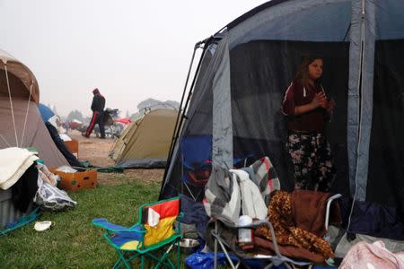 Serenity Bravo-Robertson, 10, of Paradise, stands in her family's tent at a makeshift evacuation center for people displaced by the Camp Fire in Chico, California, U.S., November 15, 2018. REUTERS/Terray Sylvester