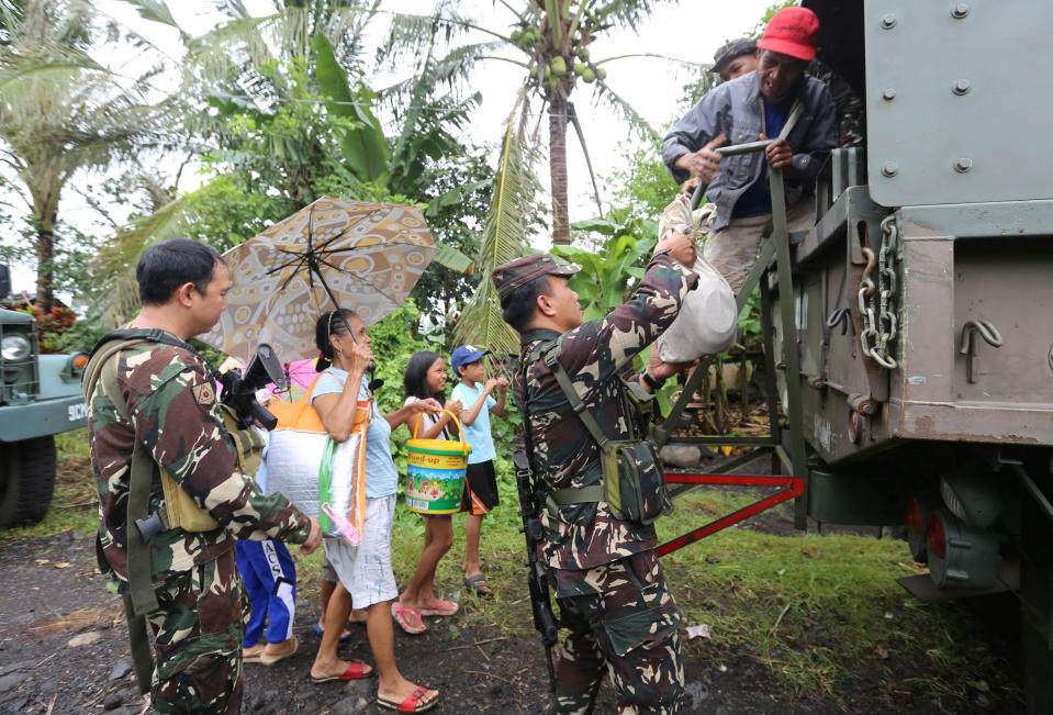 <p>Soldiers assist residents to board a military truck as they prepare to depart to the evacuation center after Mayon volcano erupted anew, in Padang town, Albay province, Philippines, Jan.16, 2018. (Photo: Stringer/Reuters) </p>