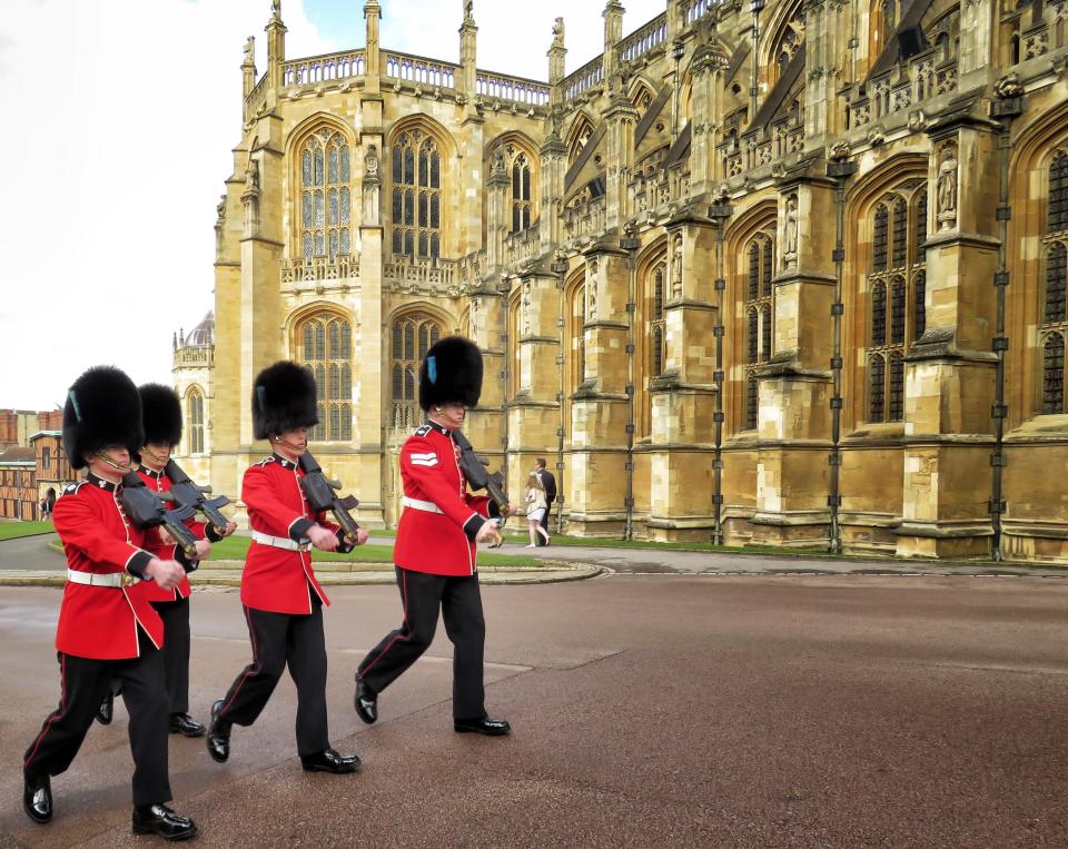 A beautiful picture of Buckingham Palace guards patrolling in their red and black uniform