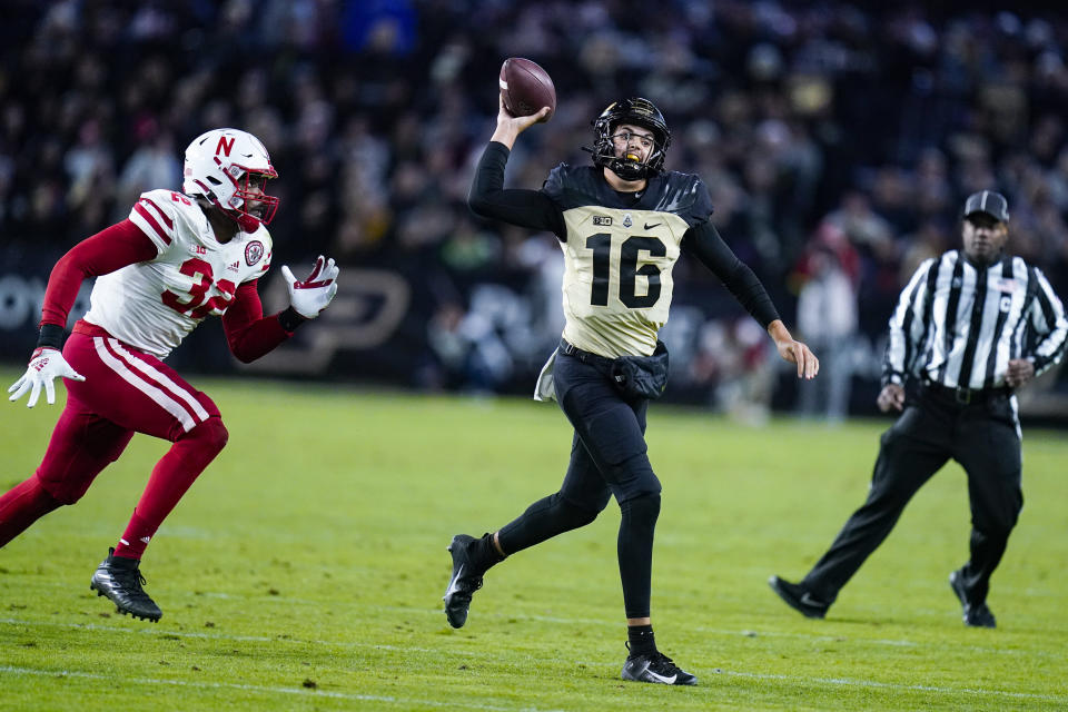 Purdue quarterback Aidan O'Connell (16) scrambles away from Nebraska defensive end Ochaun Mathis (32) during the second half of an NCAA college football game in West Lafayette, Ind., Saturday, Oct. 15, 2022. (AP Photo/Michael Conroy)