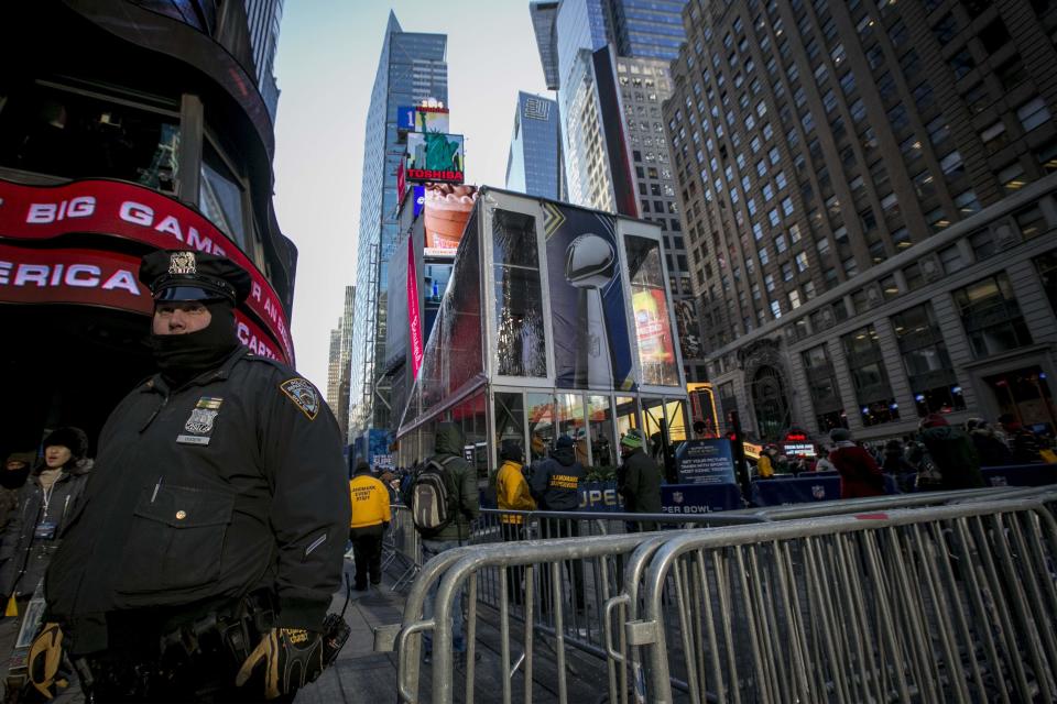 A New York City Police Department officer watches as fans walk through Times Square which has been transformed into Super Bowl Boulevard ahead of Super Bowl XLVIII in New York